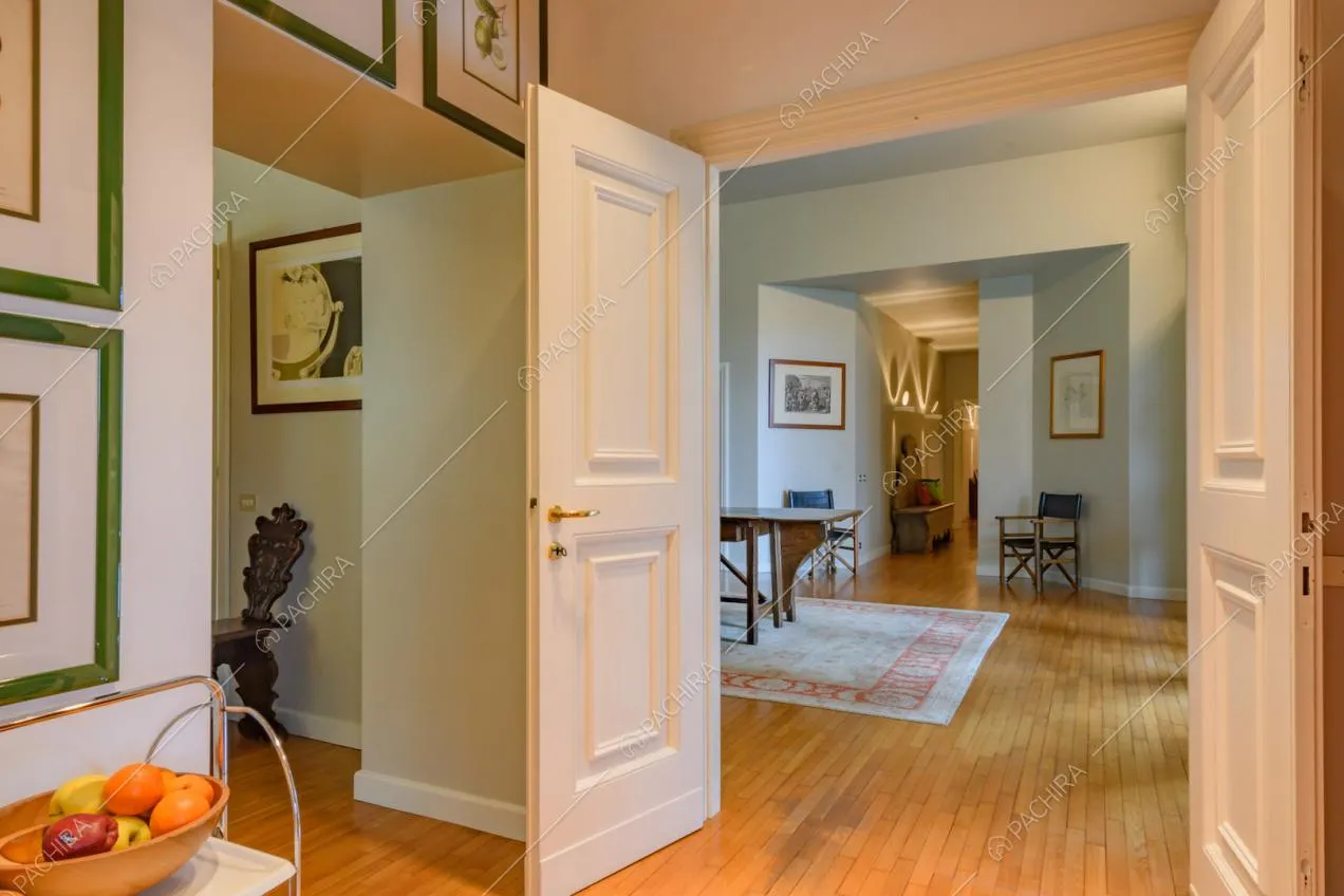 Atrio con pavimento in parquet, porte bianche con boiserie e quadri