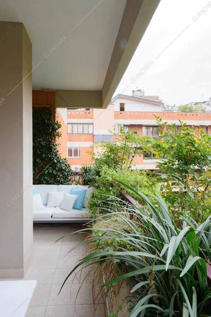Terrazza con numerose piante e divanetto bianco