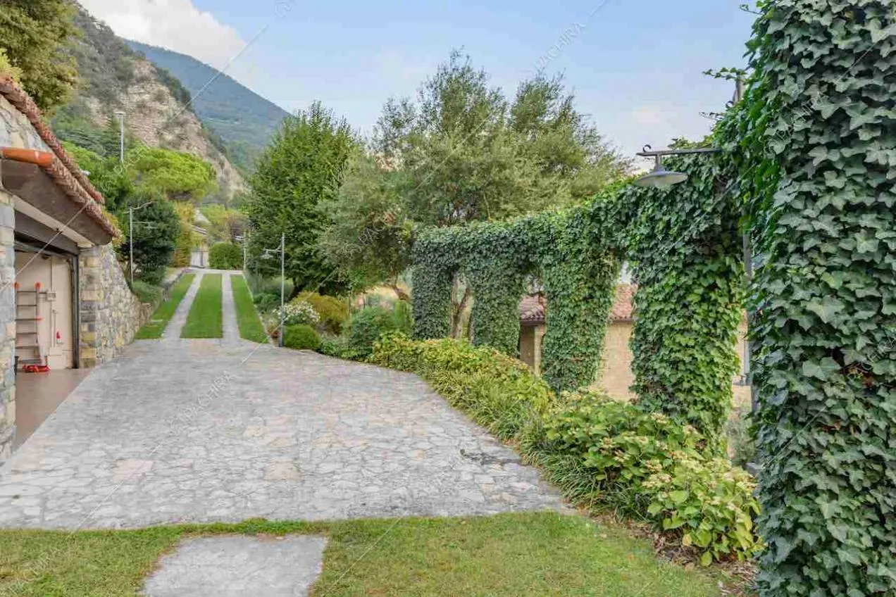 Vialetto in pietra, garage e rampicanti