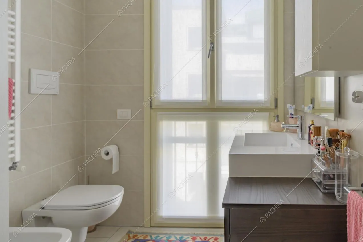 Bagno con piastrelle e mobile sottolavabo in legno