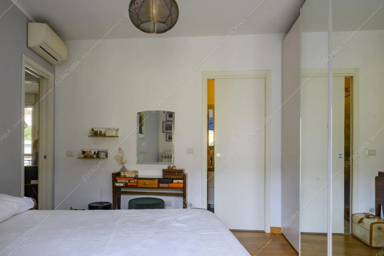Scrittoio in legno, piccole mensole, specchio e lampada a sospensione