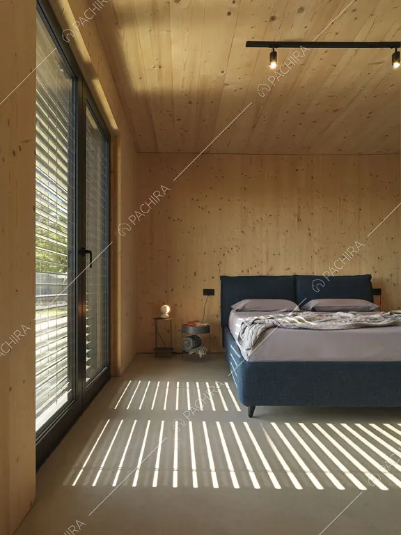 Camera da letto matrimoniale con porta-finestra, faretti sul soffitto e legno su pareti e soffitto