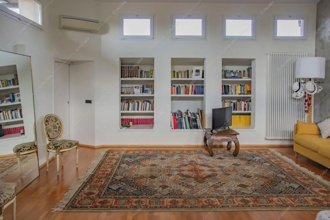 Divano giallo nella grande camera da letto con pavimento in parquet
