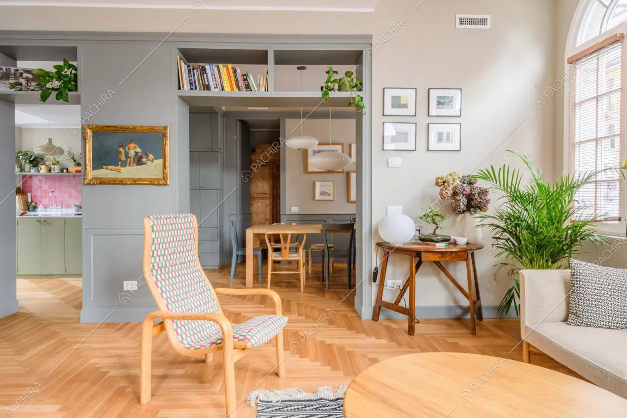 Luminoso salotto con pavimento in parquet a spina di pesce e vista su cucina e tavolo da pranzo