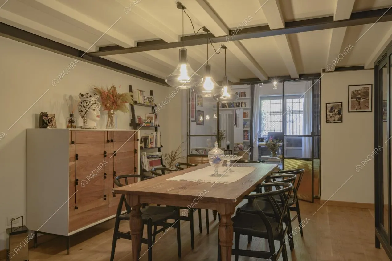 Zona pranzo con arredi in legno e ampia vetrata