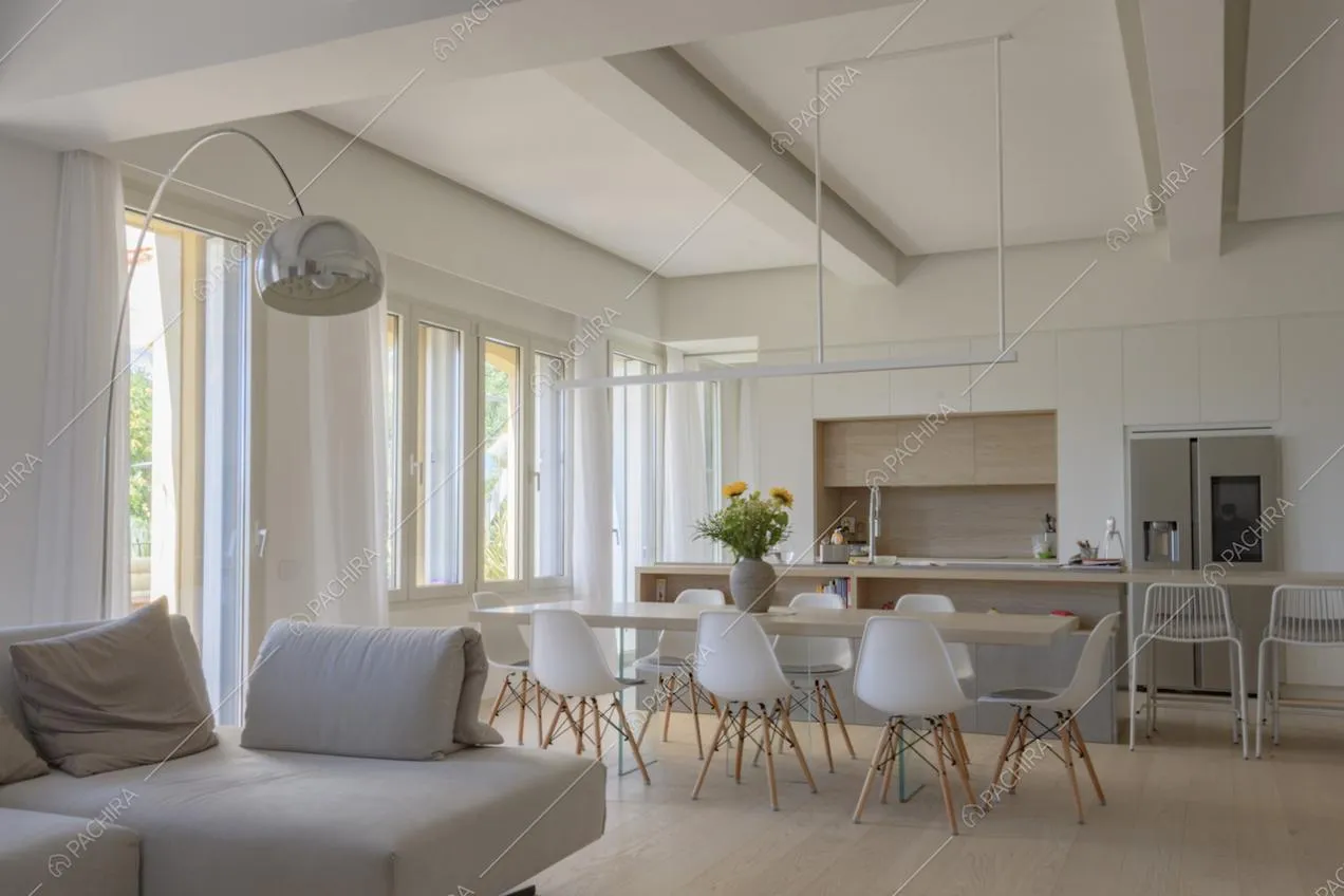 Grandi finestre lungo un lato della zona giorno e arredi di design
