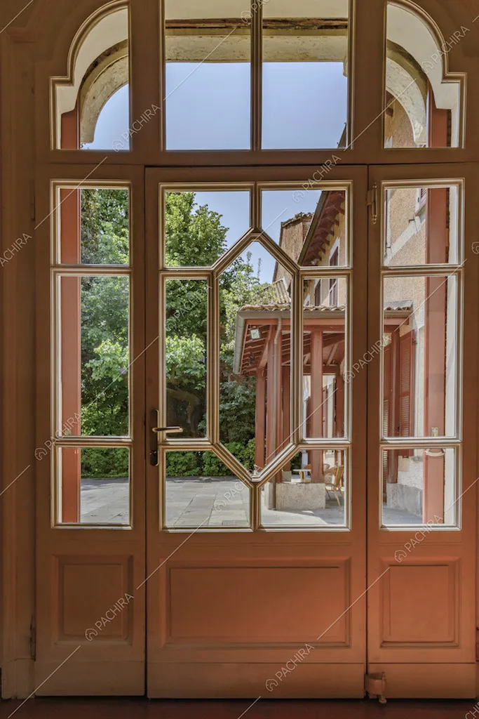 Porta finestra bianca con fantasia geometrica per accedere al cortile d'ingresso