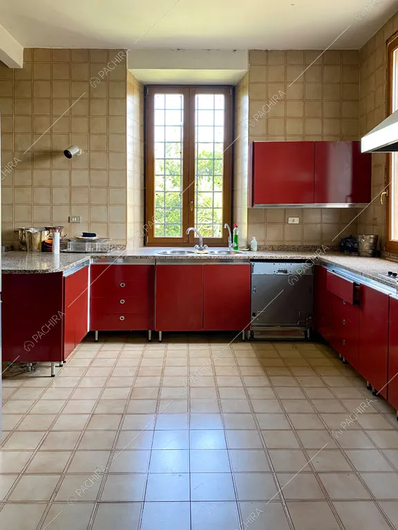 Cucina a parete rossa con piano da lavoro in marmo e fornelli a gas