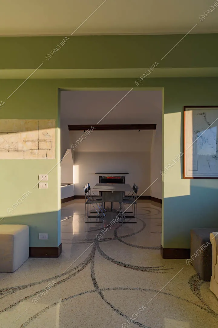 Luminosa sala con pareti verde chiaro, pavimento in parquet e scrivania