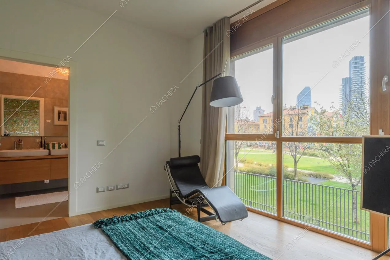 Letto matrimoniale nella camera con pavimento in parquet, bagno privato e vista sul parco
