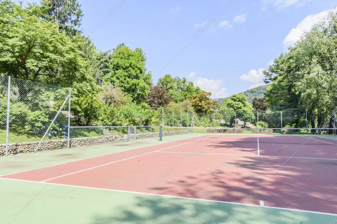 Campo da tennis con recinzione nello spazio esterno della villa