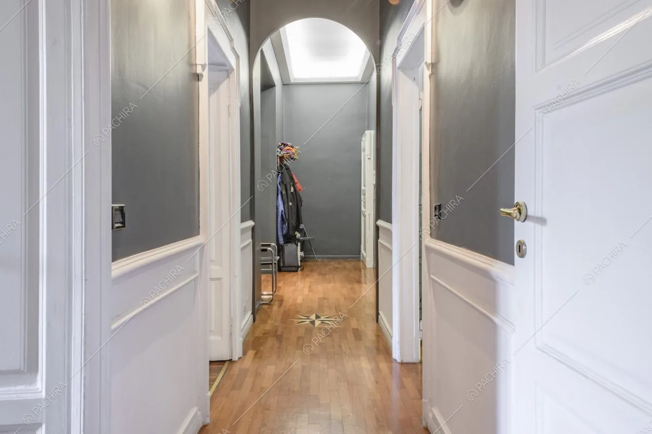 Arco nel lungo corridoio con pavimento in parquet