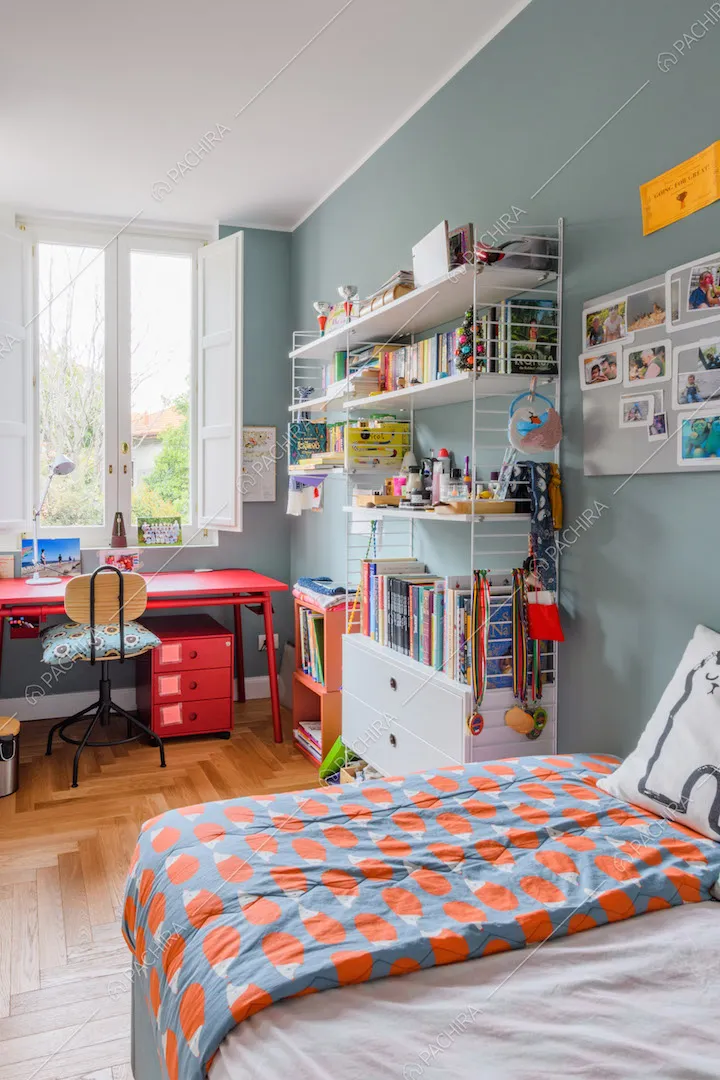 Camera da letto con scrivania rossa, pavimento in parquet a spina di pesce italiana e pareti azzurre