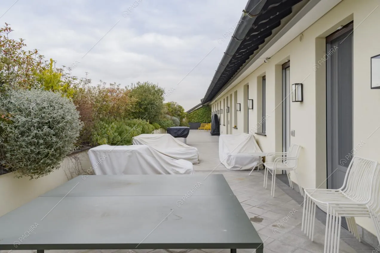 Tavolo da esterni nero e sedie sulla terrazza con piante
