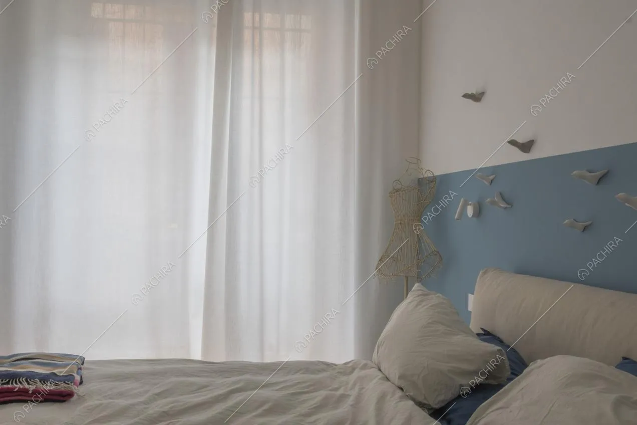 Tende leggere bianche e parete bicolor nella camera da letto