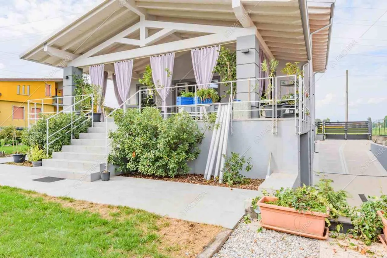 Vista sulla veranda con soffitto in travi in legno a vista dal giardino