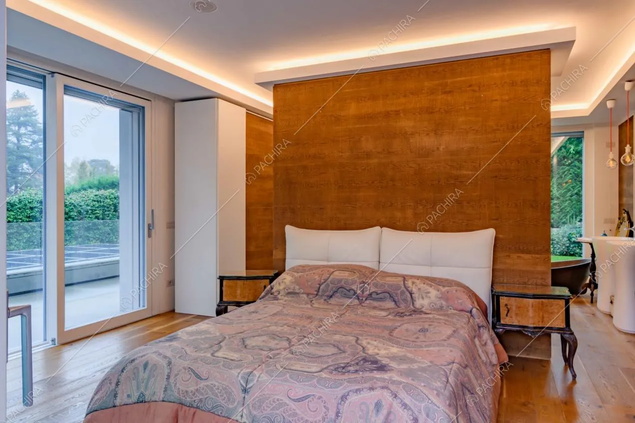 Luminosa camera da letto matrimoniale con bagno privato con vasca e pavimento in parquet
