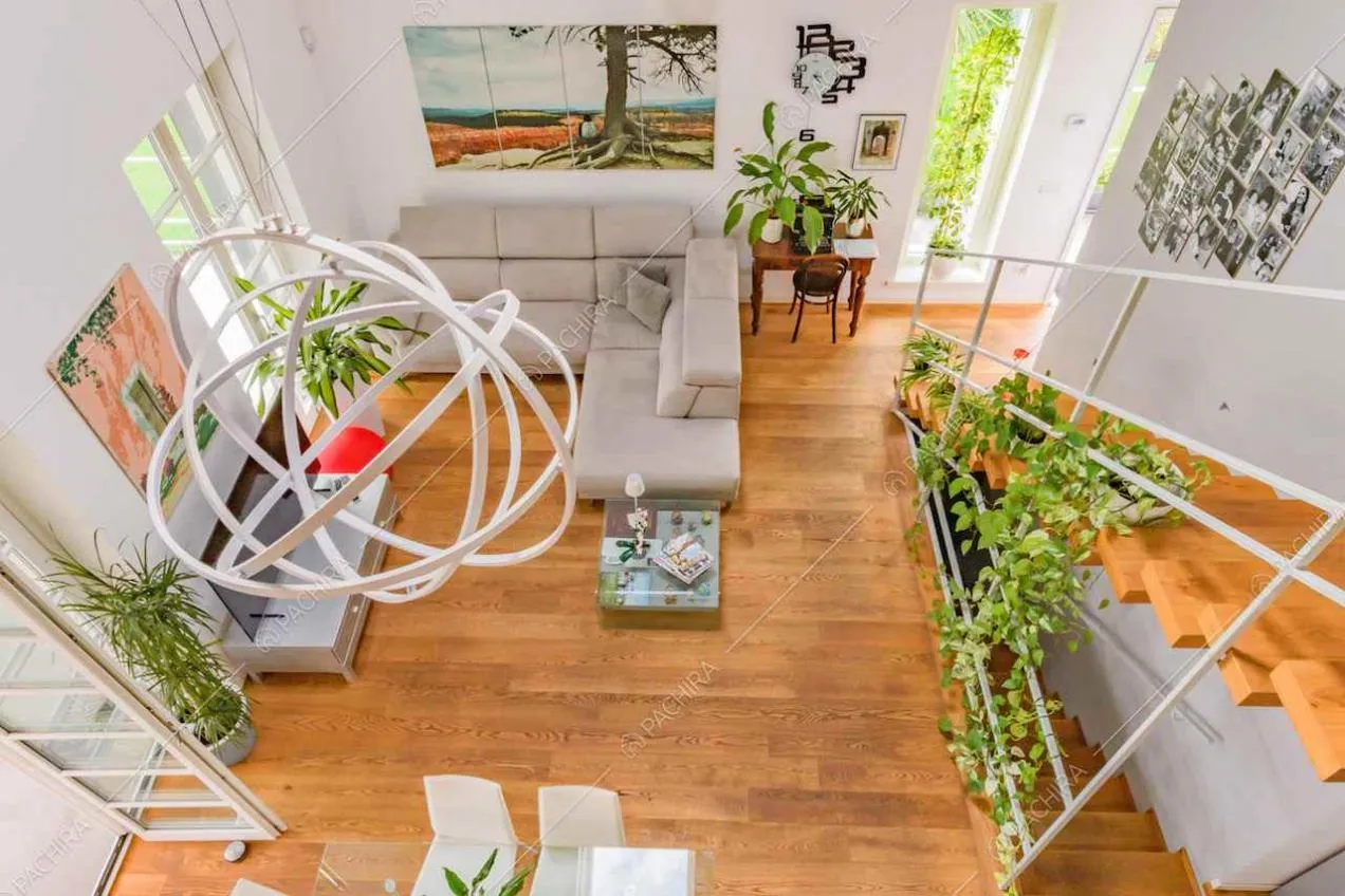 Dal soppalco vista sulla luminosa zona living con divano grigio angolare