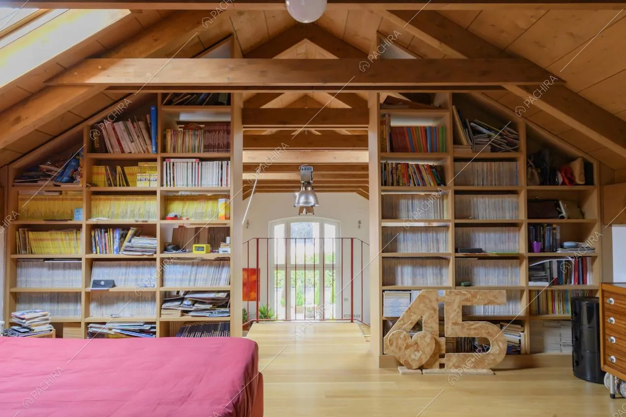 Camera da letto con libreria a parete al piano superiore della location e vista sul salone