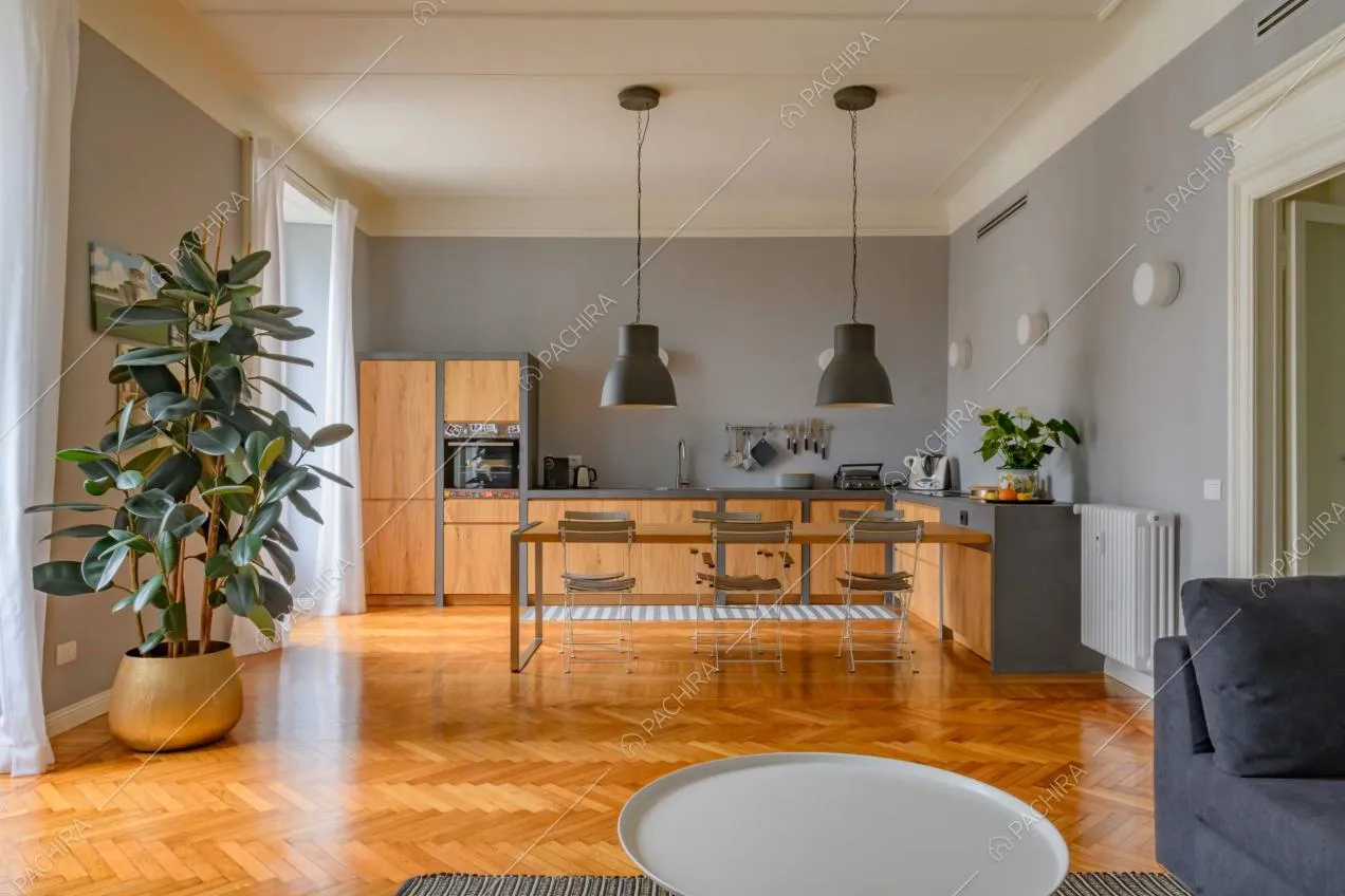 Cucina a parete a vista nella zona living dalle pareti grigie e dal pavimento in parquet