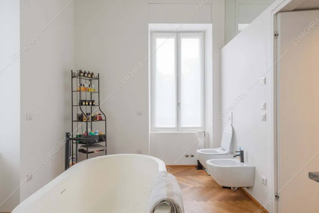 Vasca nel bagno privato della camera da letto matrimoniale con pavimento in parquet a spina di pesce