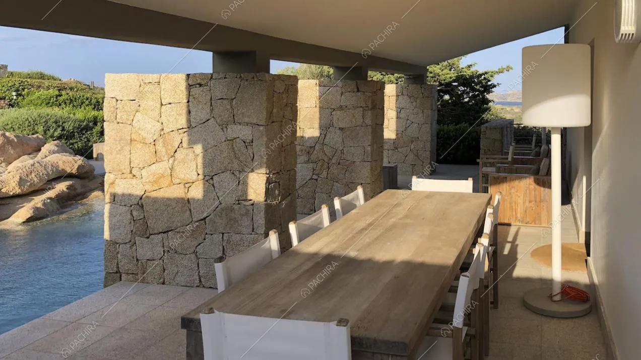 Tavolo da pranzo rettangolare in legno e lampada a bordo piscina