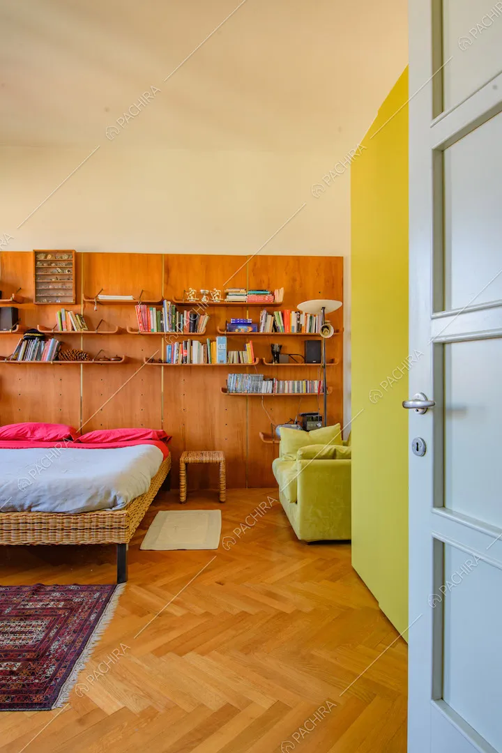 Pavimento in parquet a spina di pesce e parete in legno nella camera da letto matrimoniale