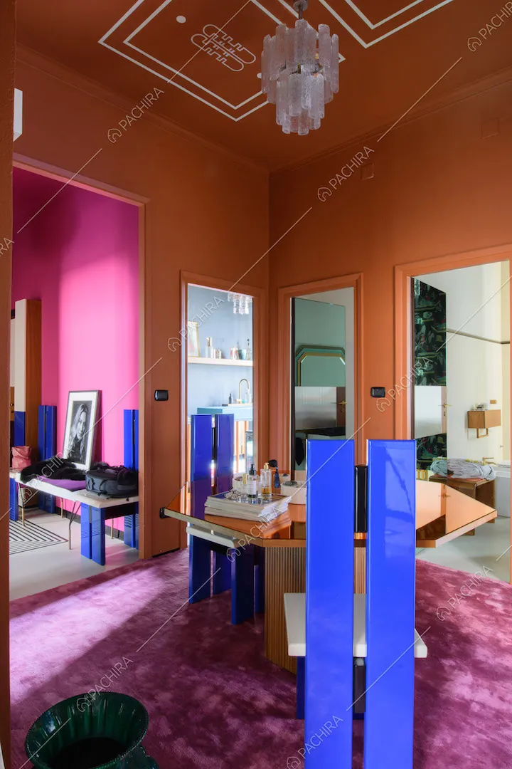 Sedie di design con schienale blu elettrico e tavolo arancione con piano a specchio