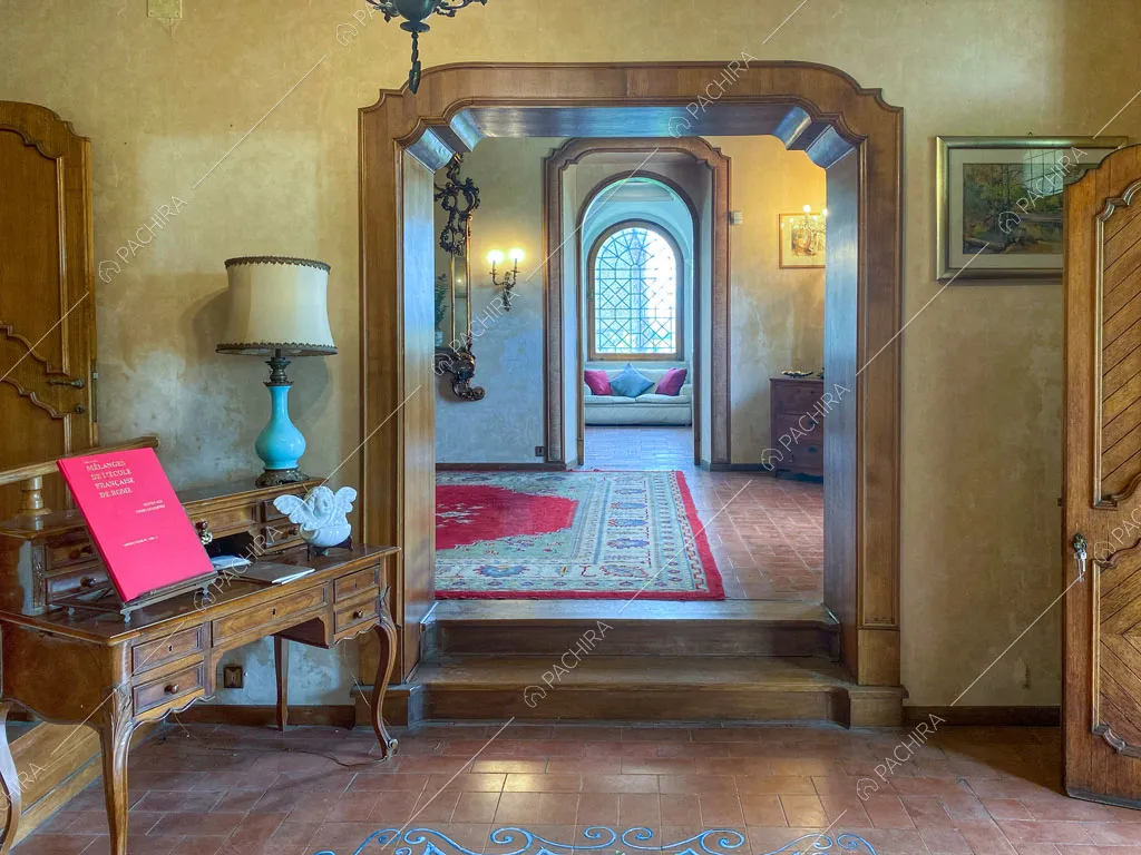 Atrio con antico scrittoio, boiserie sulle pareti e vista sulla sala con divanetto