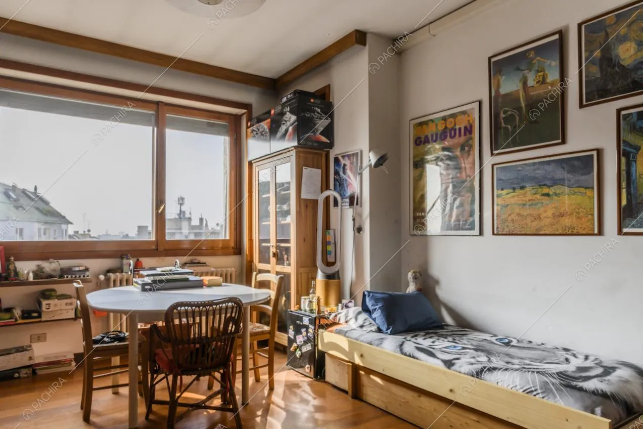 Letto singolo, tavolo rotondo, quadri appesi alla parete e vista panoramica