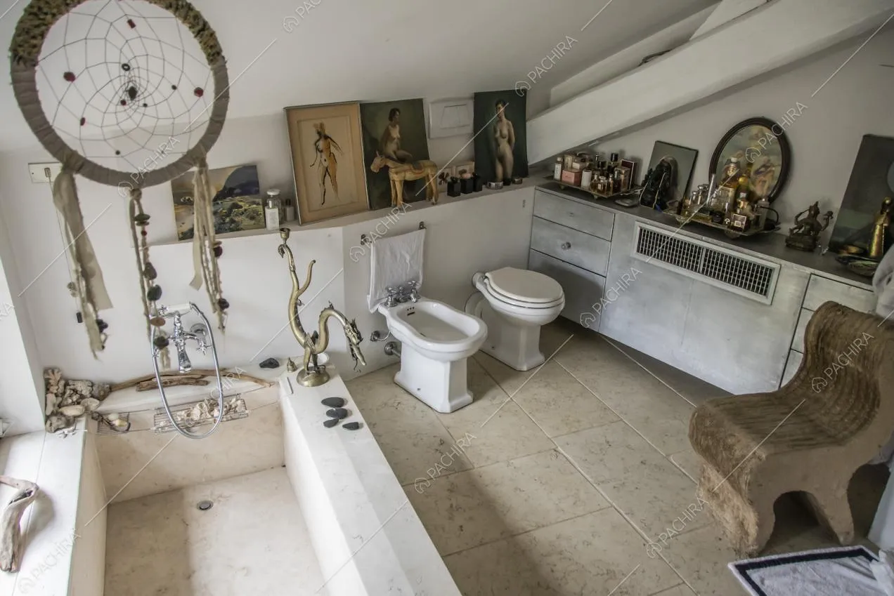 Bagno in stile vintage con vasca, ritratti e soprammobili