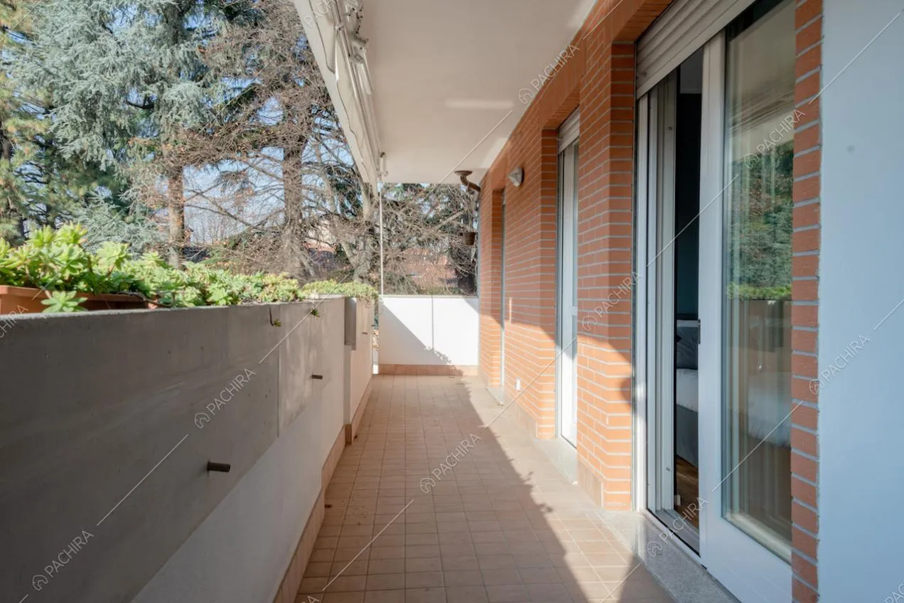 Balcone con pareti in mattoni e piante in vaso
