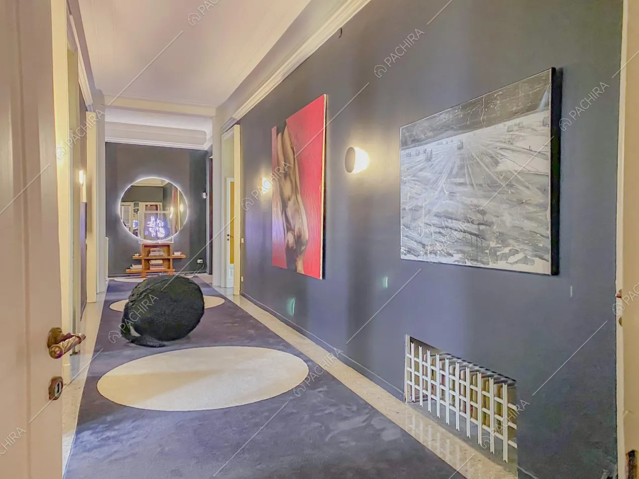 Quadri moderni appesi alla parete color scuro del corridoio