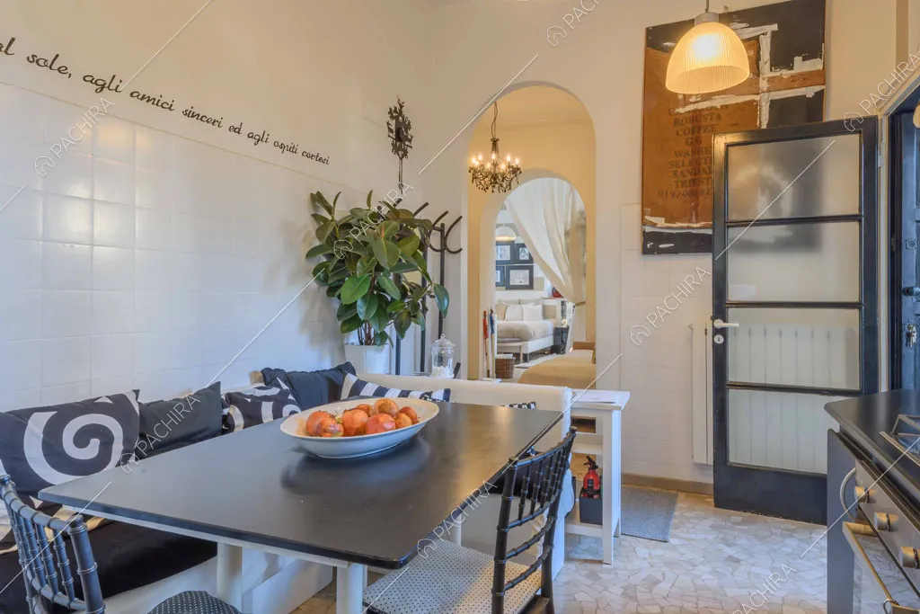 Tavolo da pranzo nero nella cucina con parete in mattonelle bianche e porta-finestra