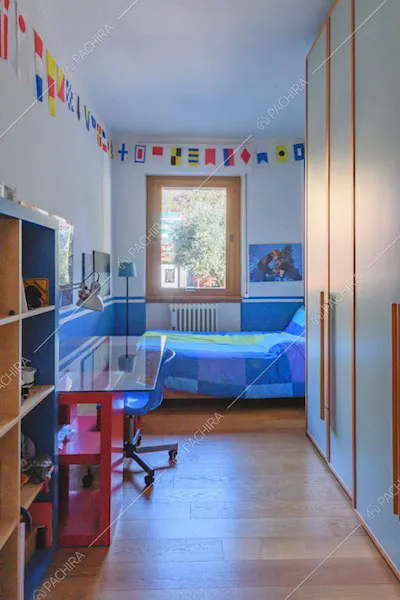 Camera da letto con scrivania, pavimento in parquet e armadio a tutta parete