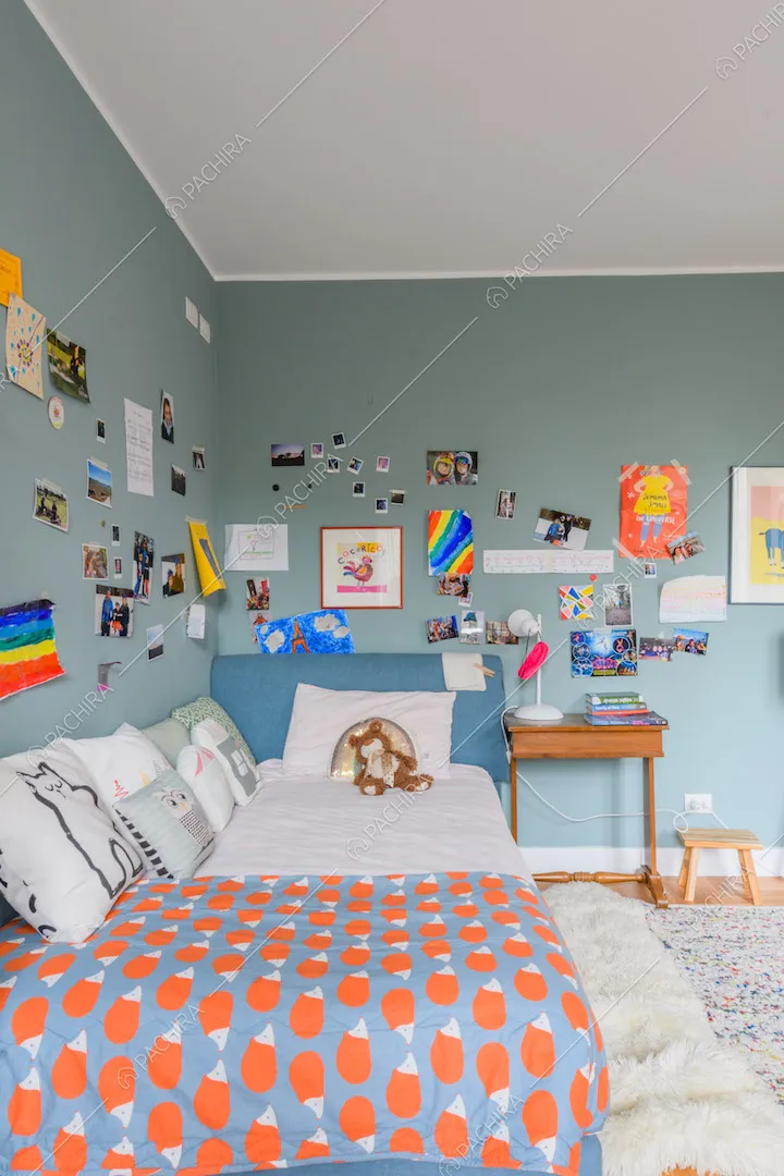 Letto della camera con pareti azzurre e pavimento in parquet a spina di pesce italiana