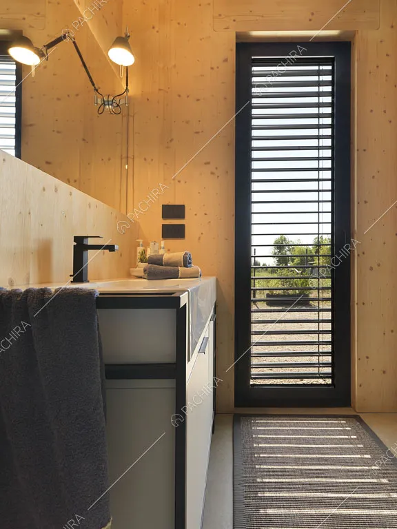 Vetrata nel bagno privato della camera da letto matrimoniale con pareti in legno 