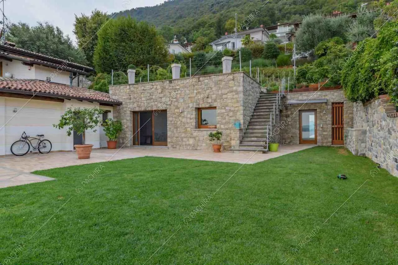 Vista sugli esterni in pietra dal giardino della villa