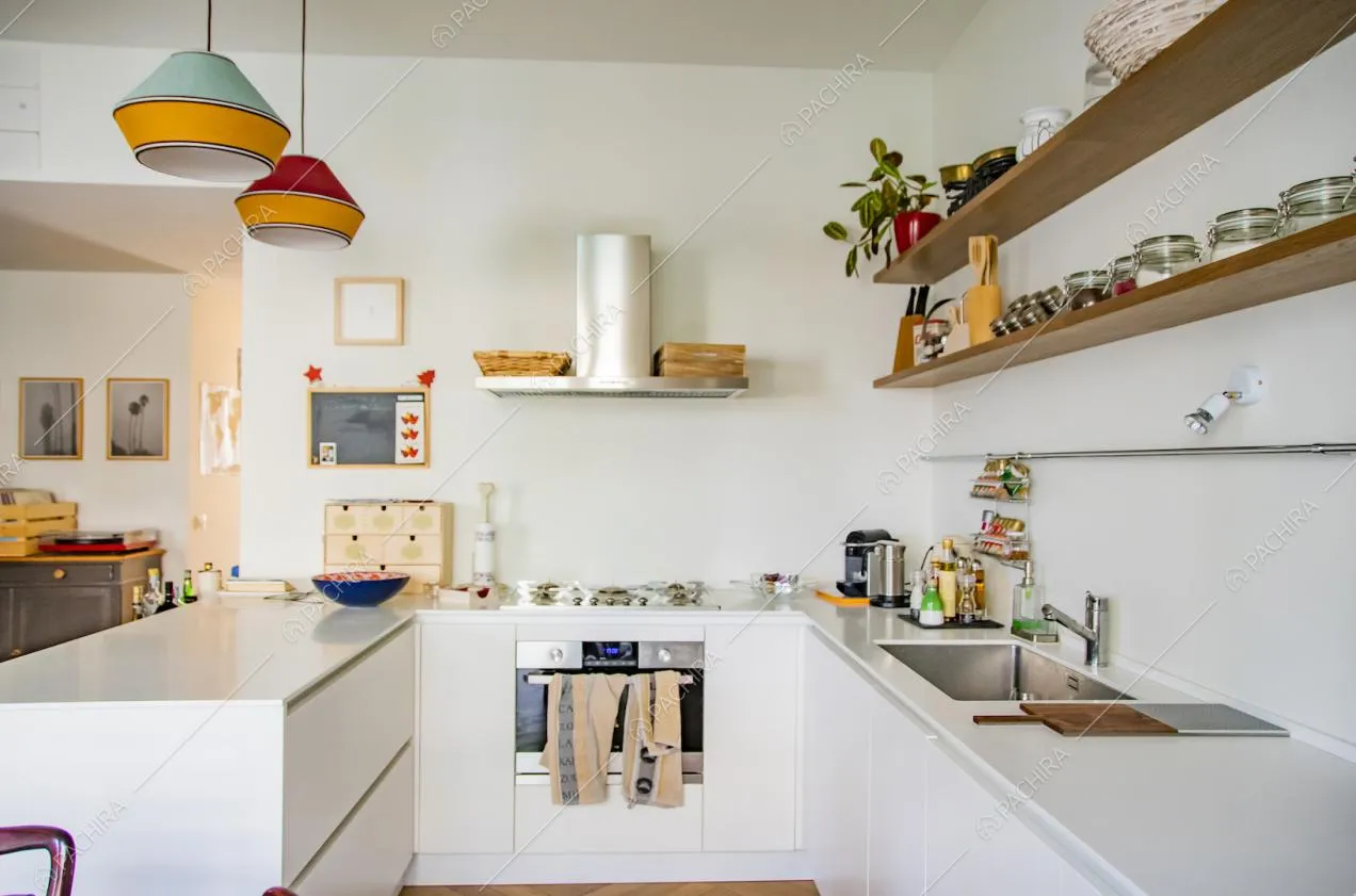 Cucina a vista bianca con piano cottura a induzione