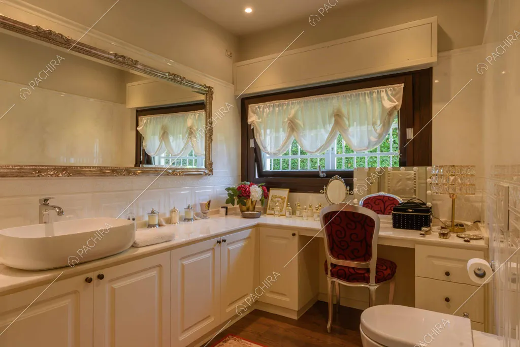 Grande bagno con pavimento in parquet, tavolino da trucco e boiserie sui mobili