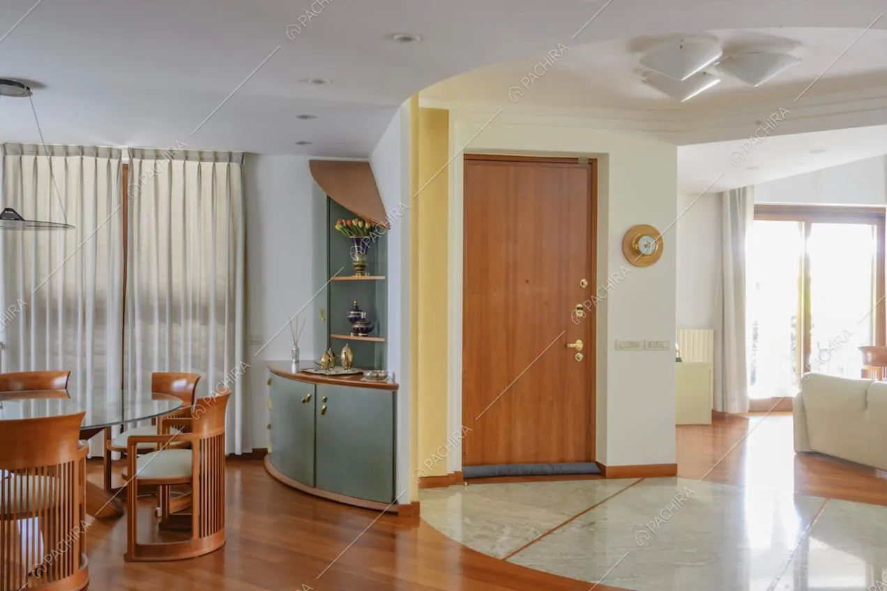 Ingresso della location, tavolo da pranzo e scorcio sul salotto