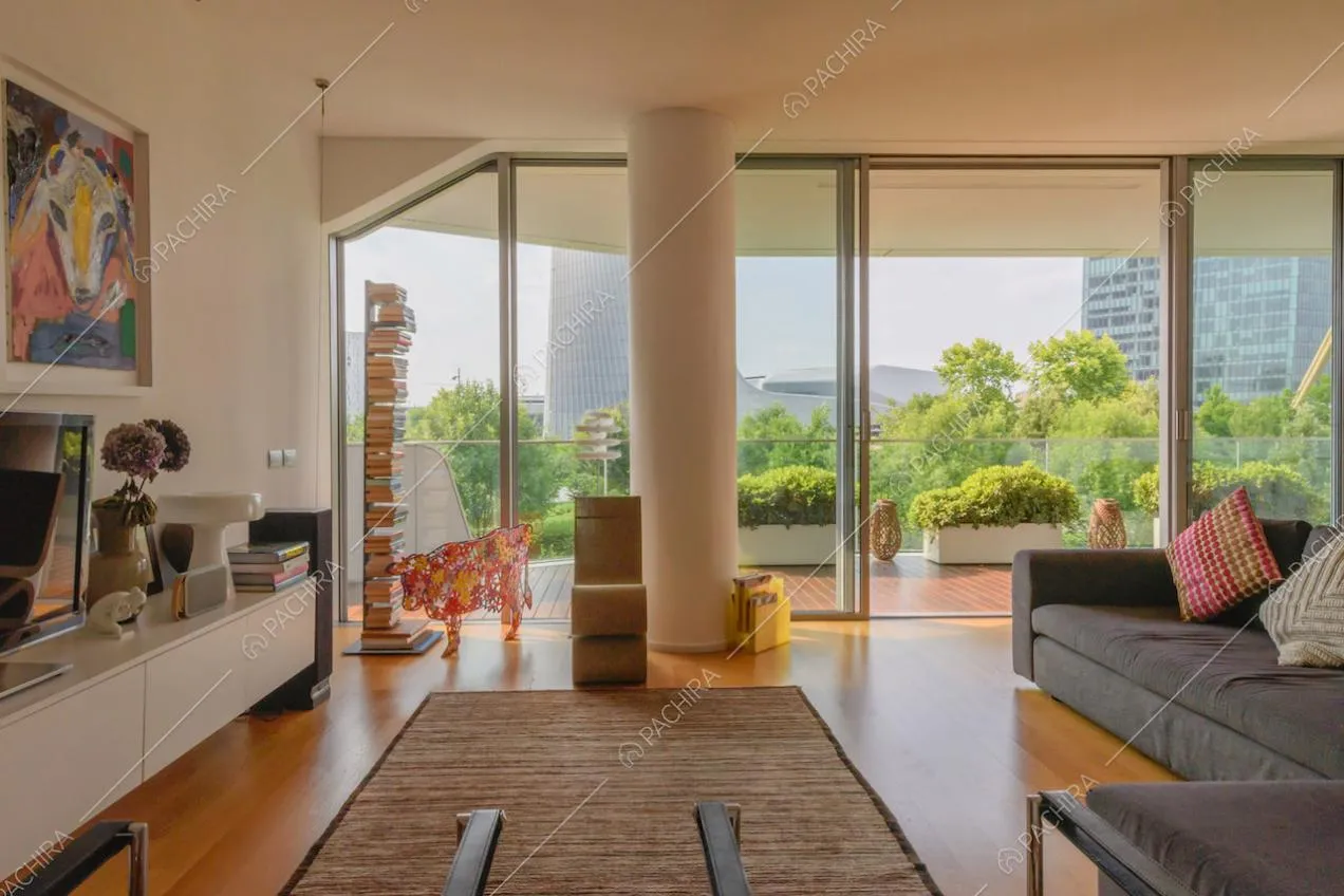 Pavimento in parquet nella zona living con finestre scorrevoli e colonna