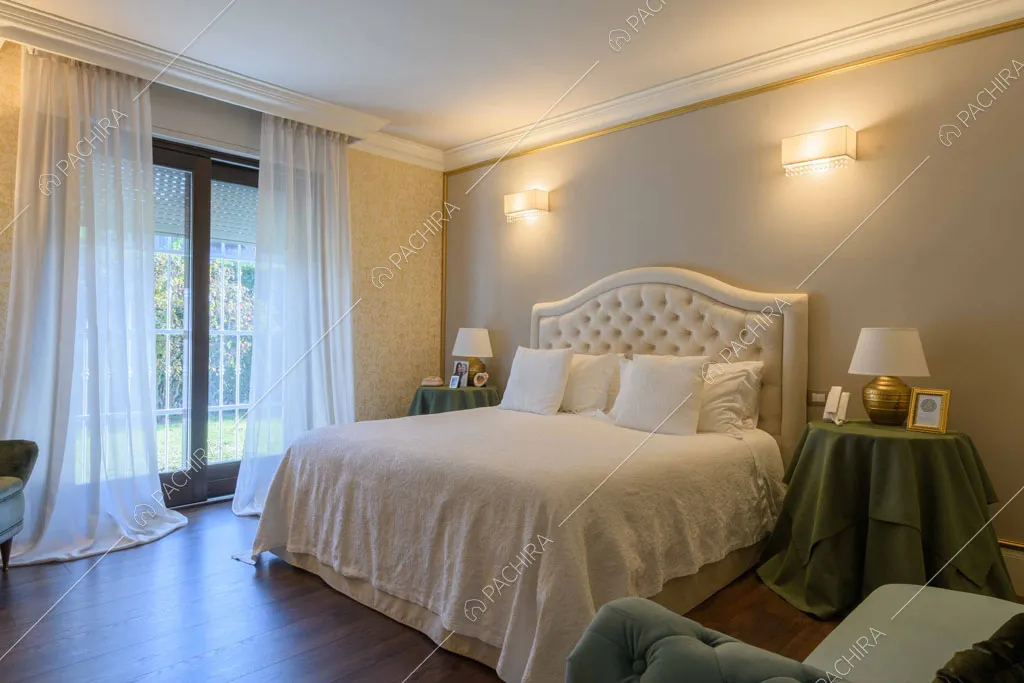 Luminosa camera da letto matrimoniale con parete grigia e porta-finestra scorrevole