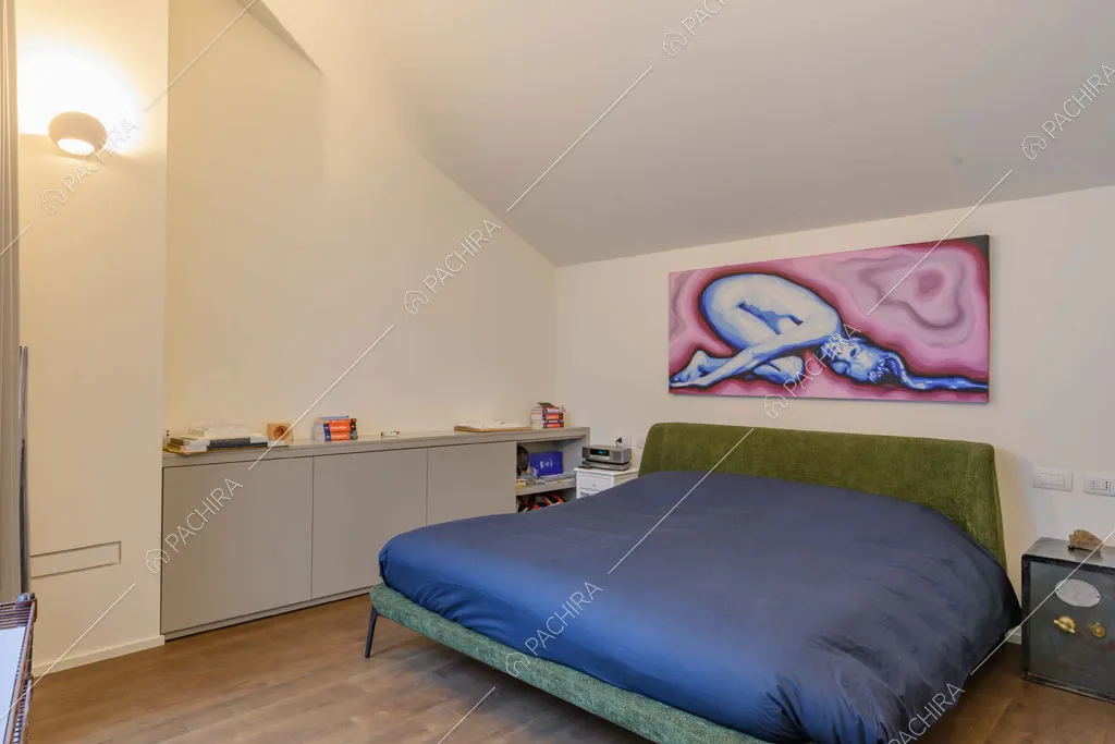 Camera da letto matrimoniale con pavimento in parquet e pareti bianche