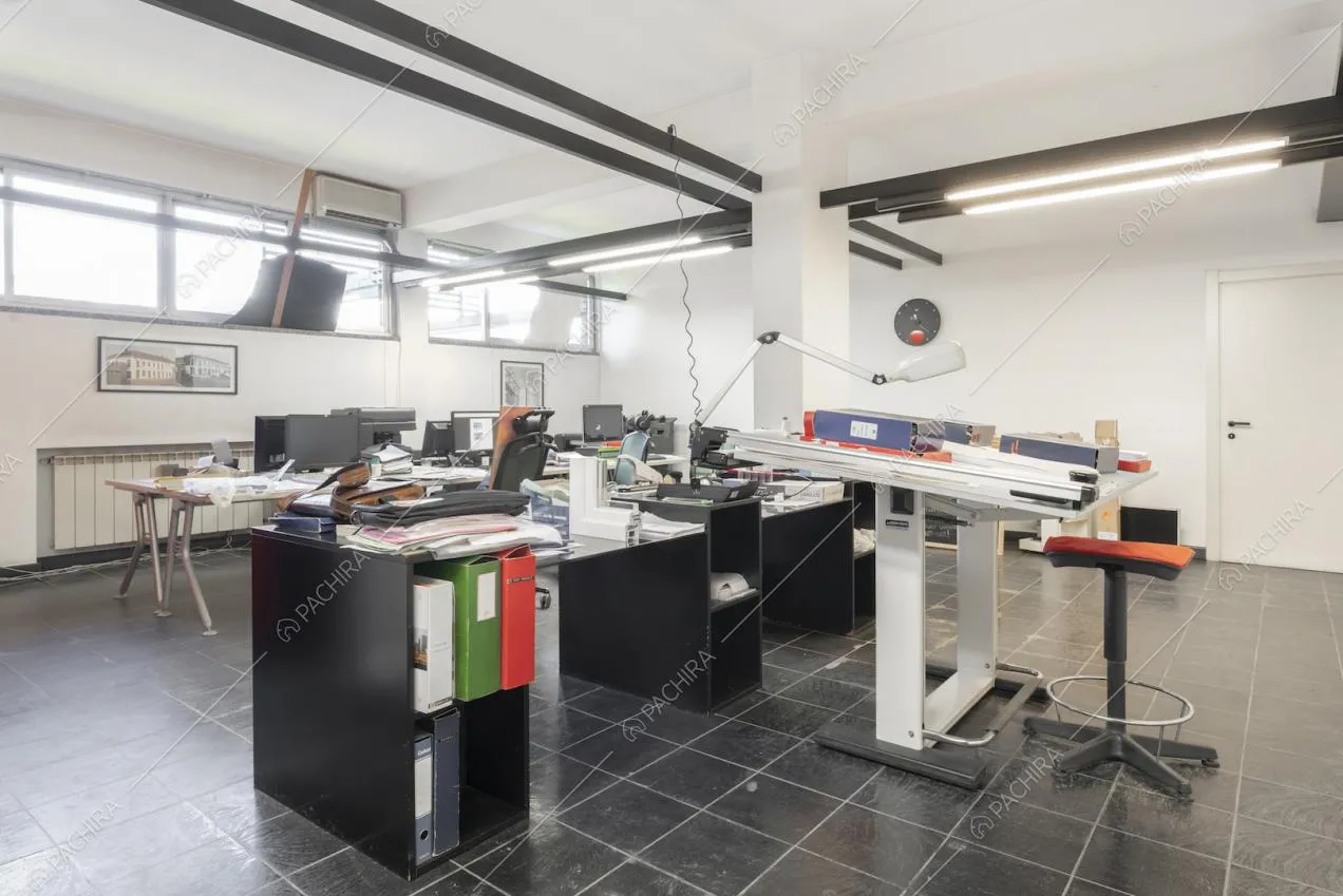 Ufficio con tavoli, scaffali e luci al neon al piano terra 