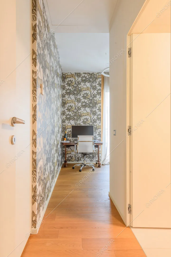 Corridoio con carta da parati a fantasia tropicale e pavimento in parquet