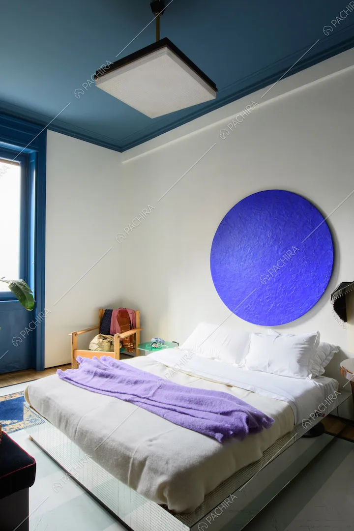 Camera da letto matrimoniale con soffitto blu e pareti bianche
