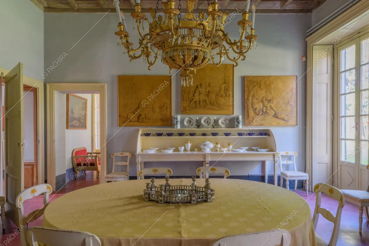 Tavolo da pranzo nella grande sala con porta-finestra e pavimento in piastrelle rosse