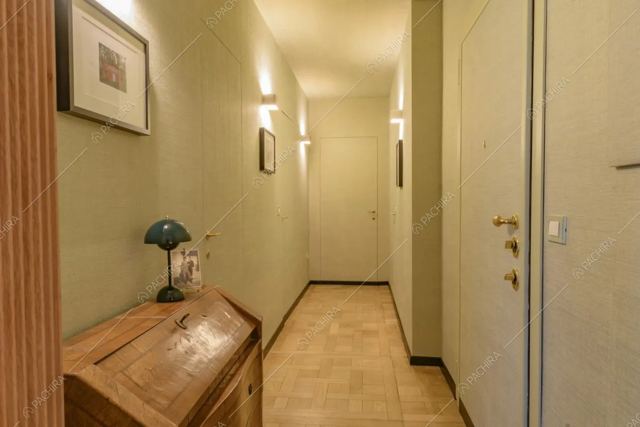 Corridoio con pavimento in parquet e pareti con carta da parati 