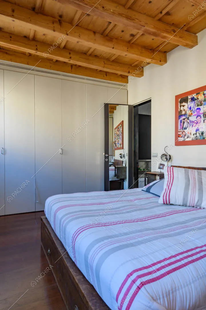 Camera da letto matrimoniale con pavimento in parquet e soffitto in travi in legno a vista
